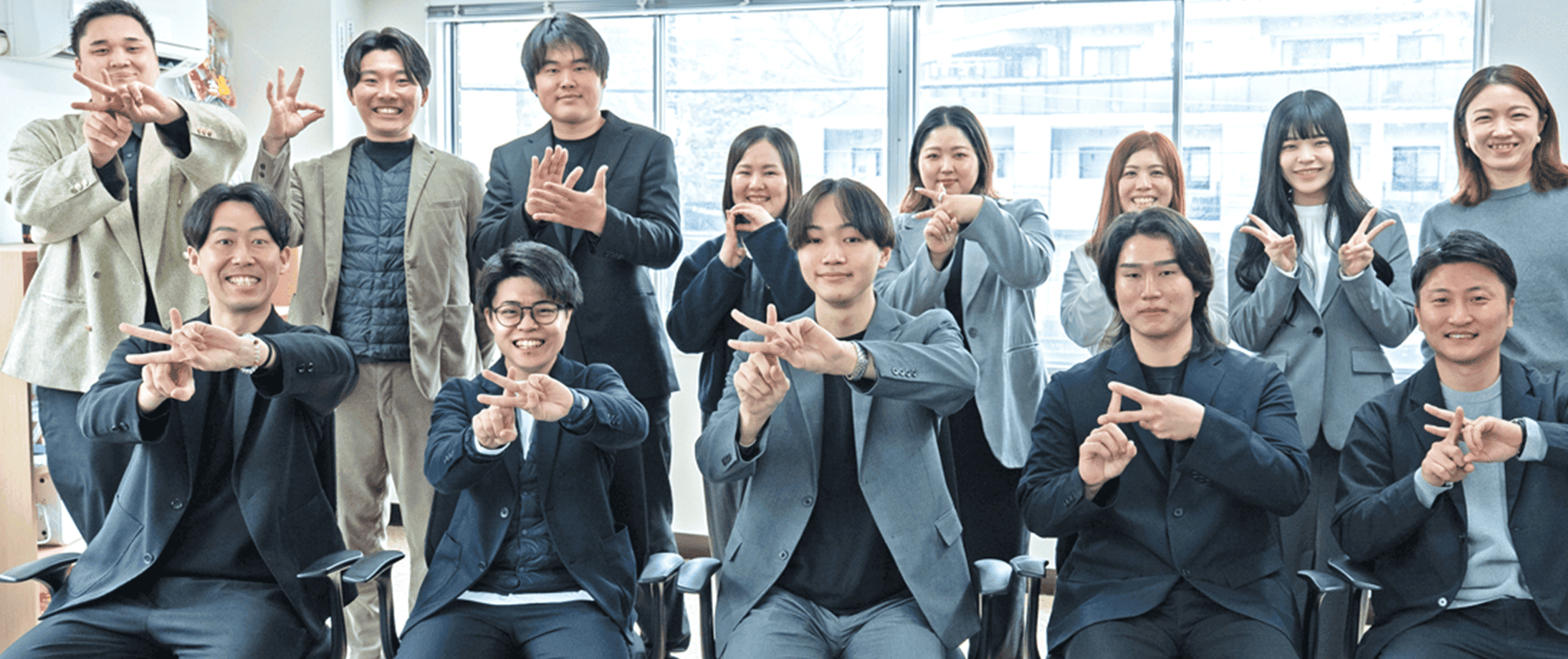 企業チームの集合写真 - Key-partnersのスタッフ全員がポーズを取るオフィスでのグループショット